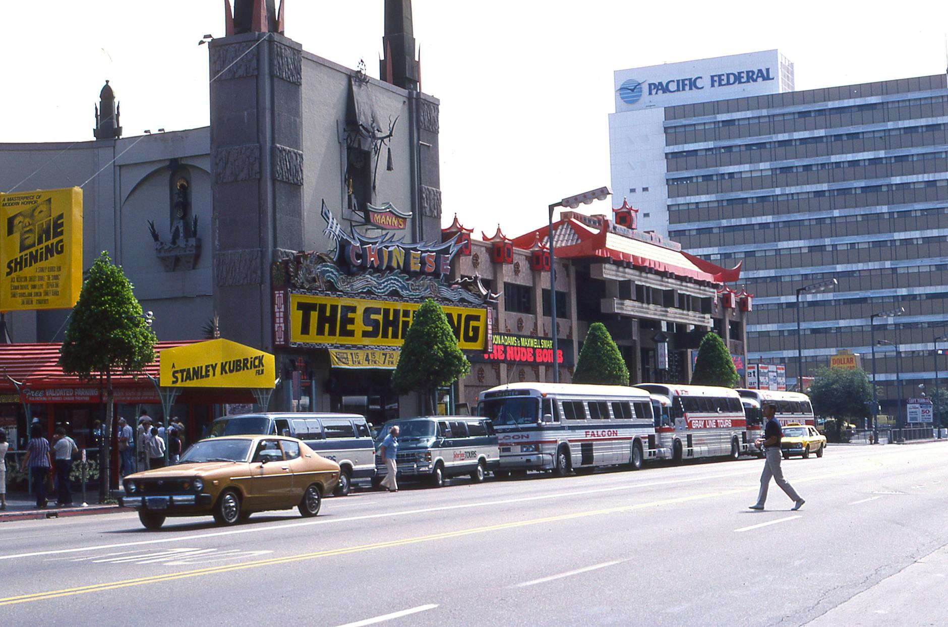 A 1980s movie theater marquee displaying The Shining on a busy street