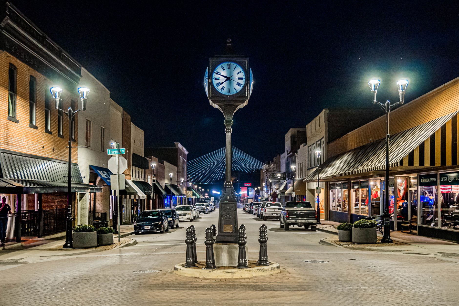 Downtown Cape Girardeau’s Main Street at night, with the street clock and Bill Emerson bridge lit in the distance.